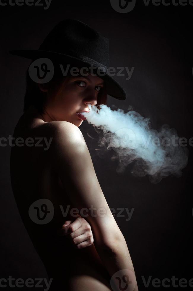 porträtt av en ung flicka i de rök av cigaretter foto