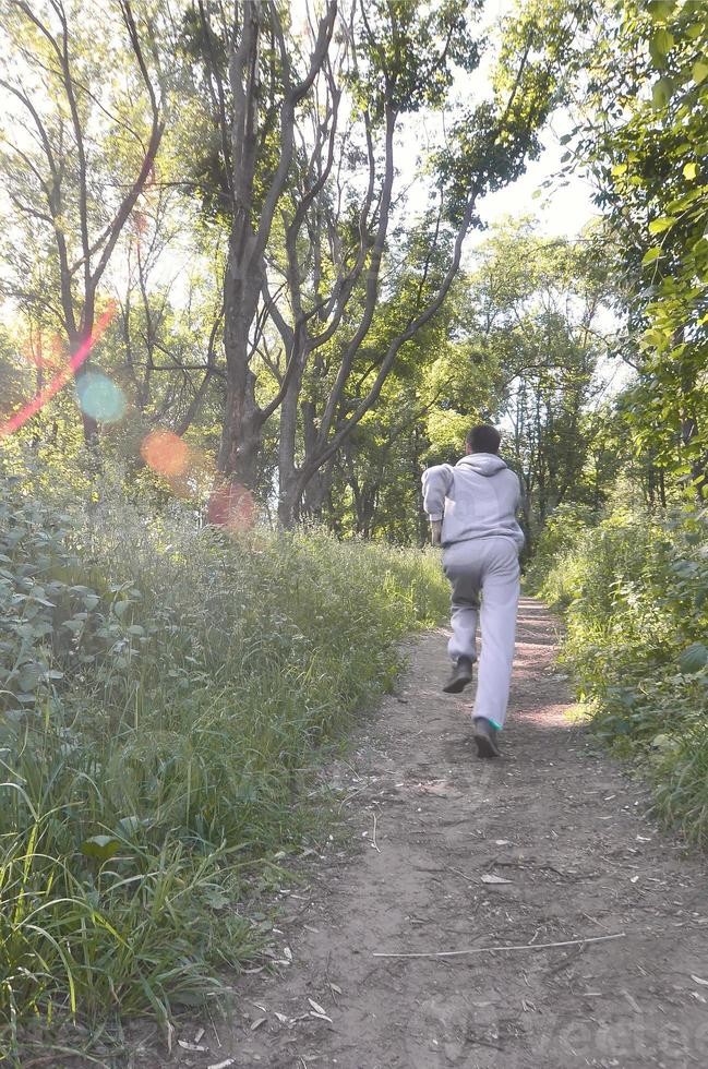 en ung kille i en grå sporter kostym kör längs de väg bland de foto