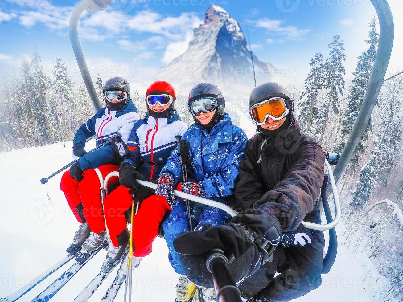 Fantastisk skön se åka skidor tillflykt i schweiz med kabel- stollift transport glad ung vänner skidåkare på åka skidor hiss foto