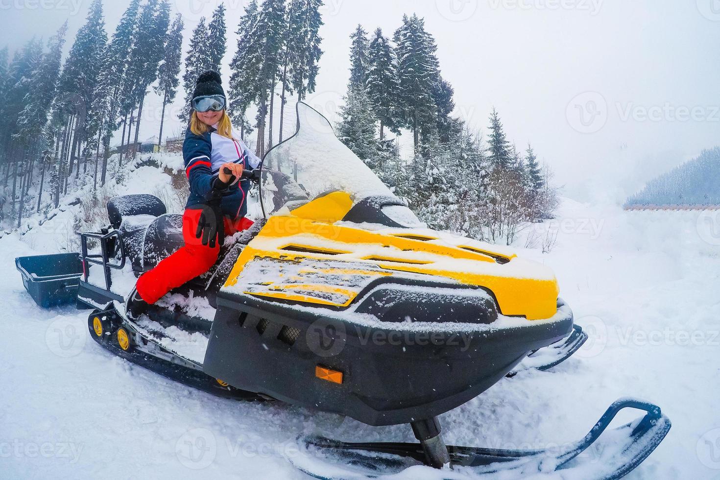 porträtt av kvinna på snöskoter.koncept av snö sport och friska livsstil foto