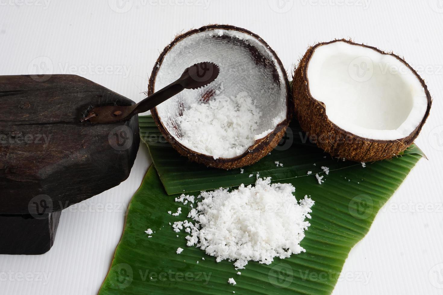 närbild kokos rivjärn verktyg, kokos skal på grön banan löv, förbereda kokos mjölk för mat eller efterrätt. begrepp thai traditionell matlagning metod. foto