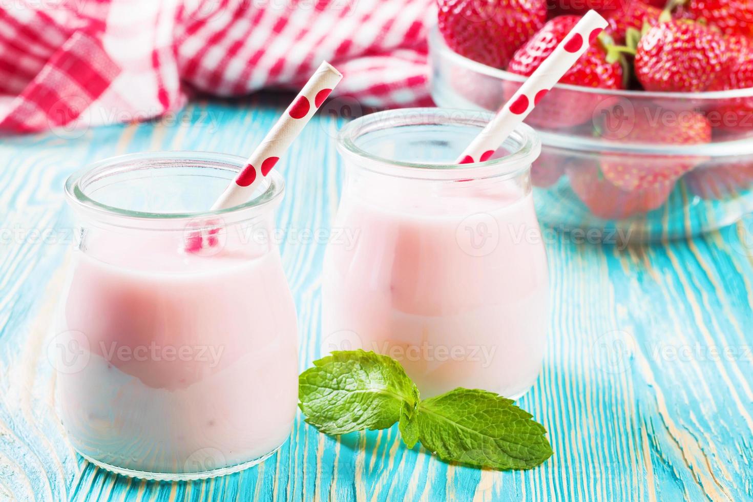 jordgubb milkshake i de glas burk på blå trä- bakgrund foto