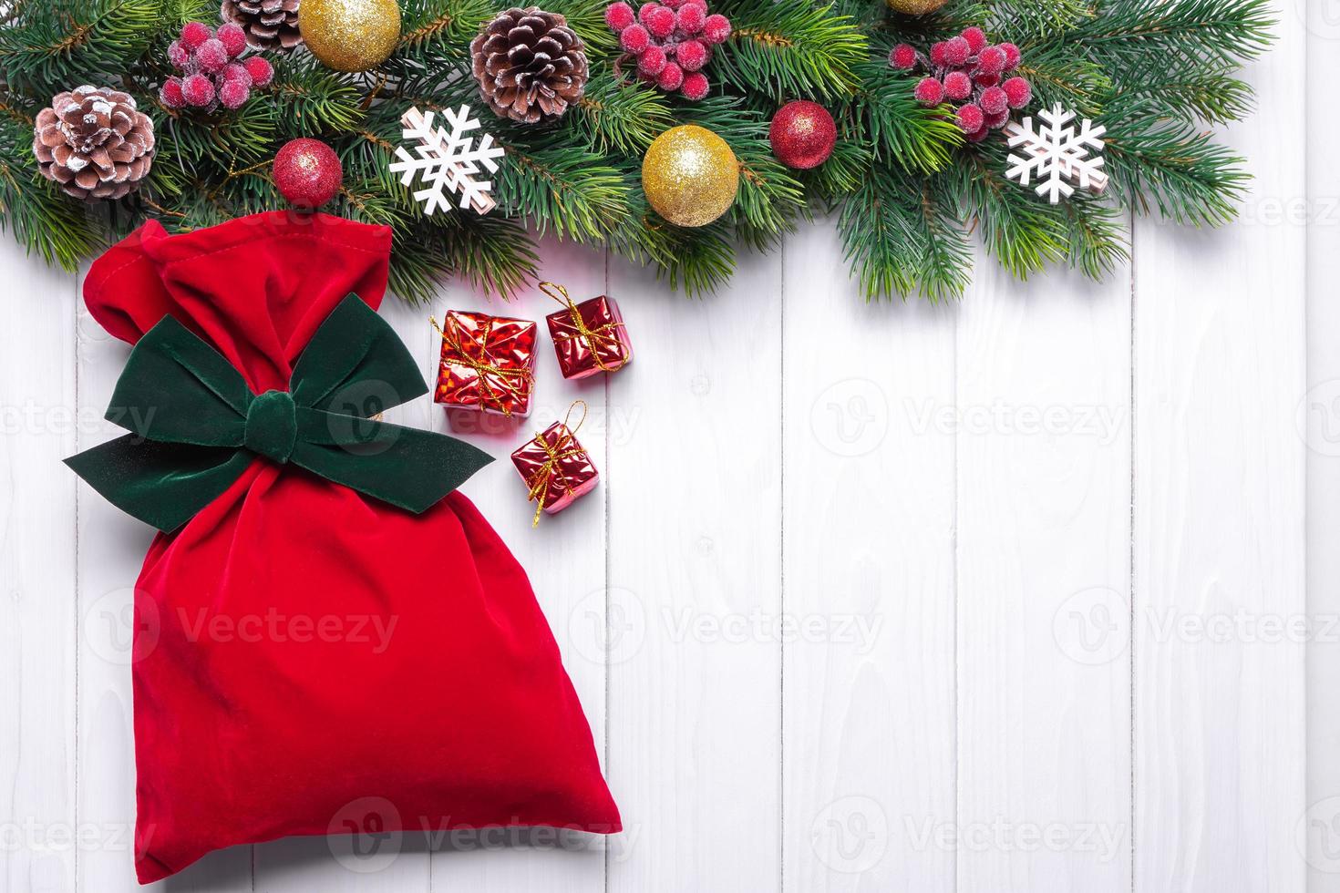 jul bakgrund med dekorerad gran träd och röd gåva väska. topp se, platt lägga med kopia Plats foto