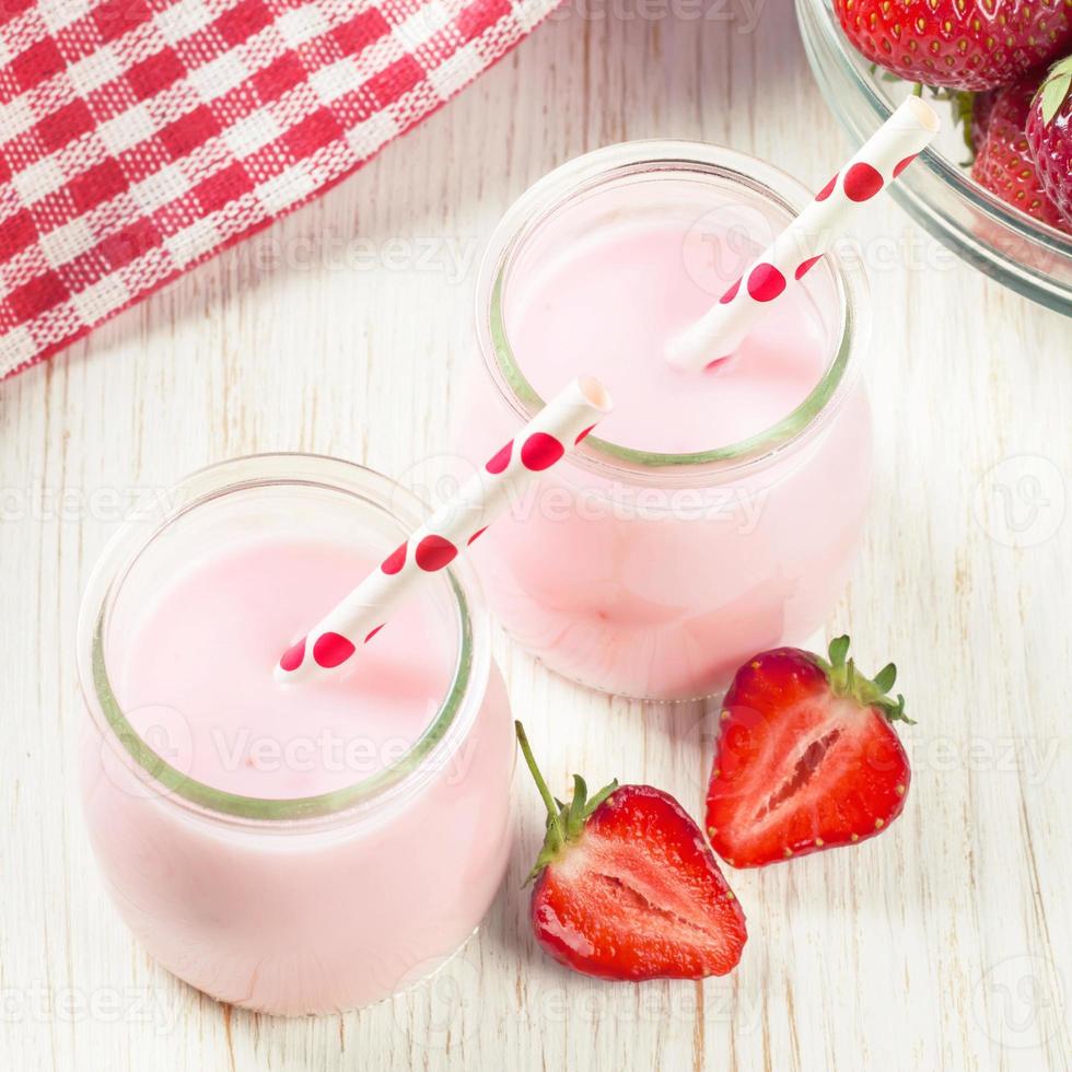 jordgubb milkshake i de glas burk på vit trä- bakgrund foto