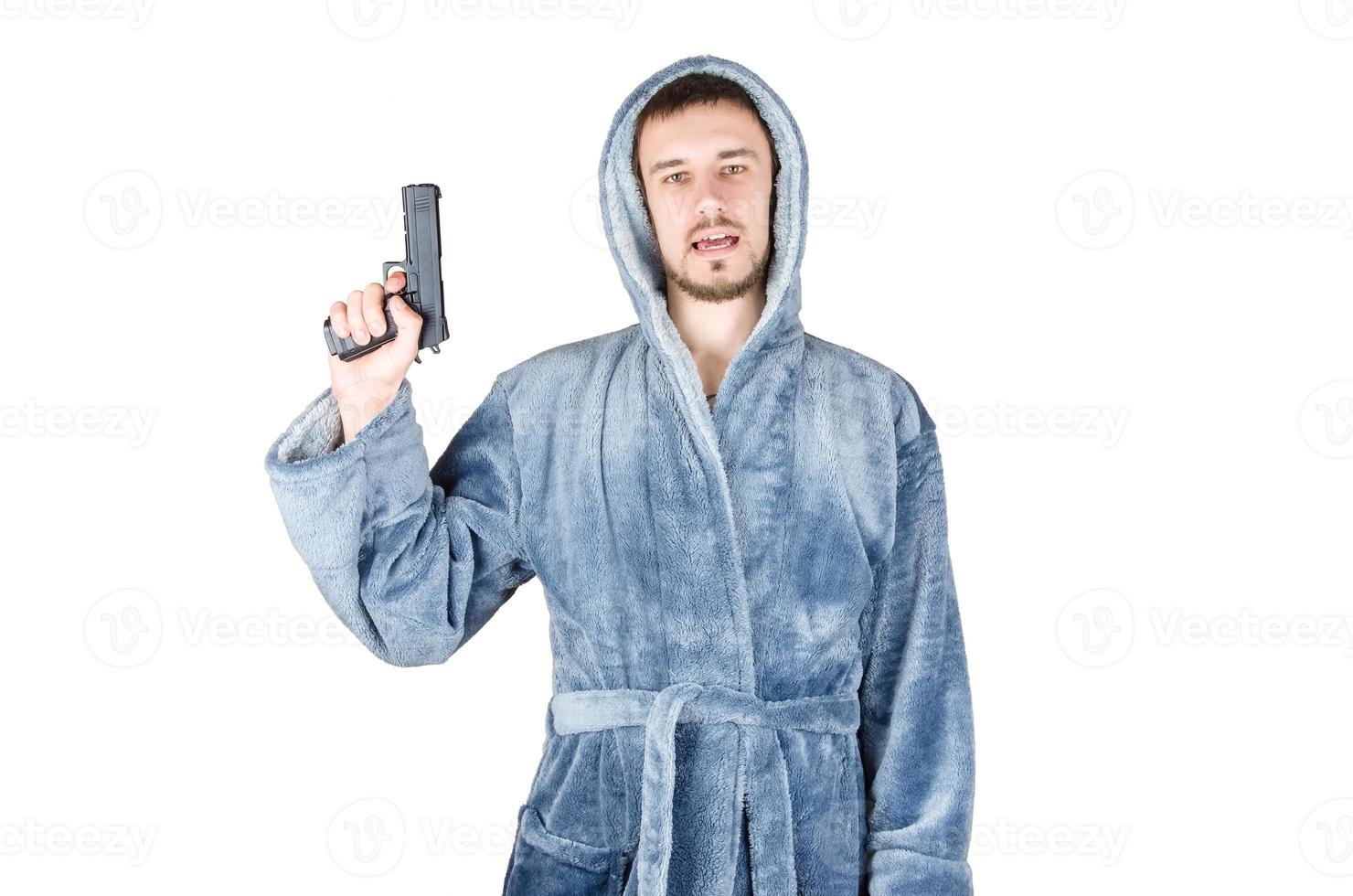 porträtt av ung caucasian skäggig man i blå morgonrock med svart skjutvapen isolerat på vit bakgrund foto