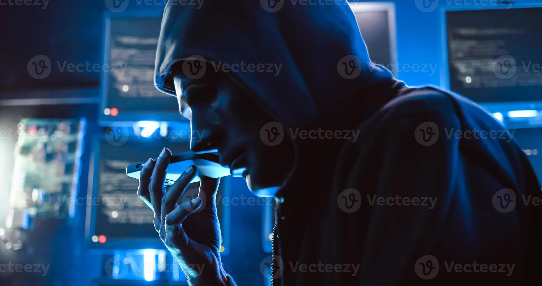 en hacker bär en mask till omslag hans ansikte är använder sig av dator till hacka data till skaffa sig lösen från offer. foto