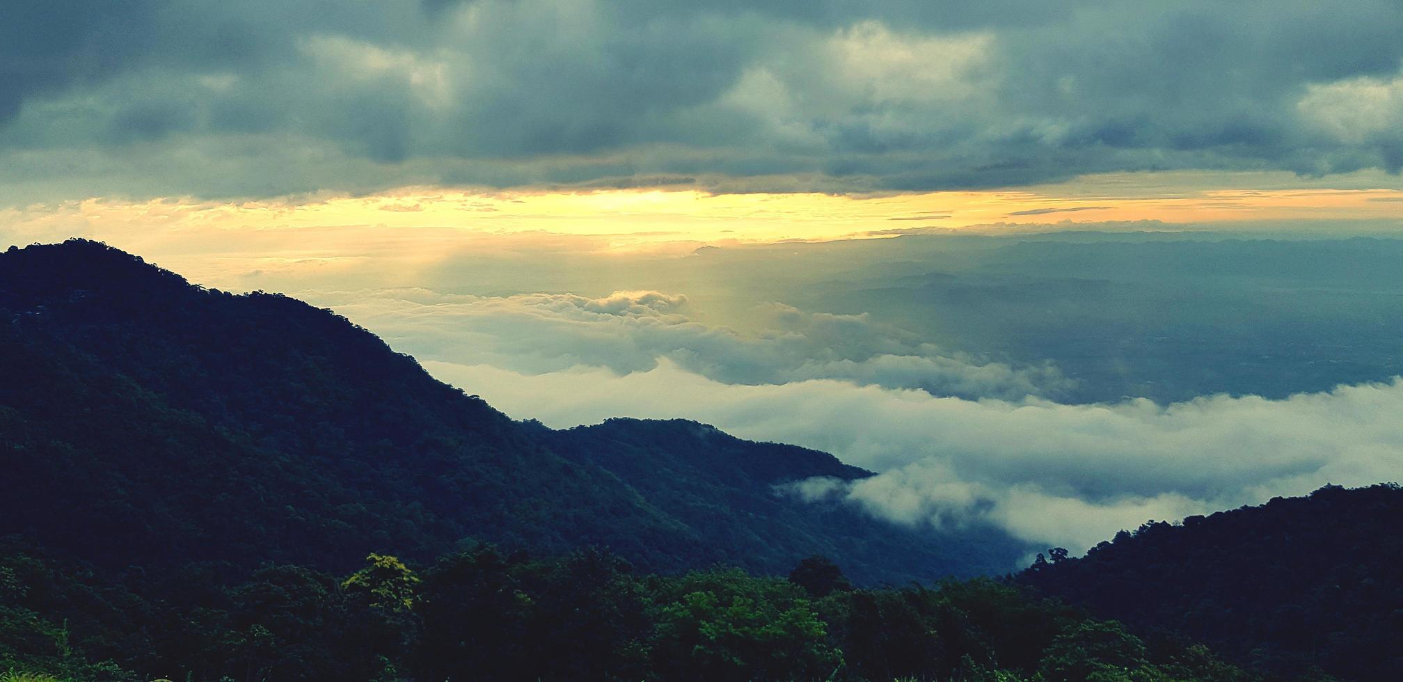 skön landskap se av grön berg med skog, dimma eller dimmig och solljus i morgon- på Phetchabun provins, thailand. clouds på kullar på ny dag. landmärke för resa och Bra luft färsk. foto