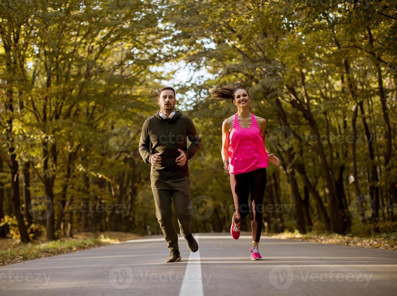 atletisk par löpning tillsammans på de skog spår foto
