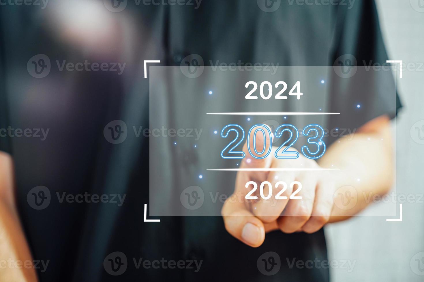 Välkommen år 2023. ny år 2022 förändra till 2023 begrepp, affärsman hand rörande på 2023 virtuell skärm. foto