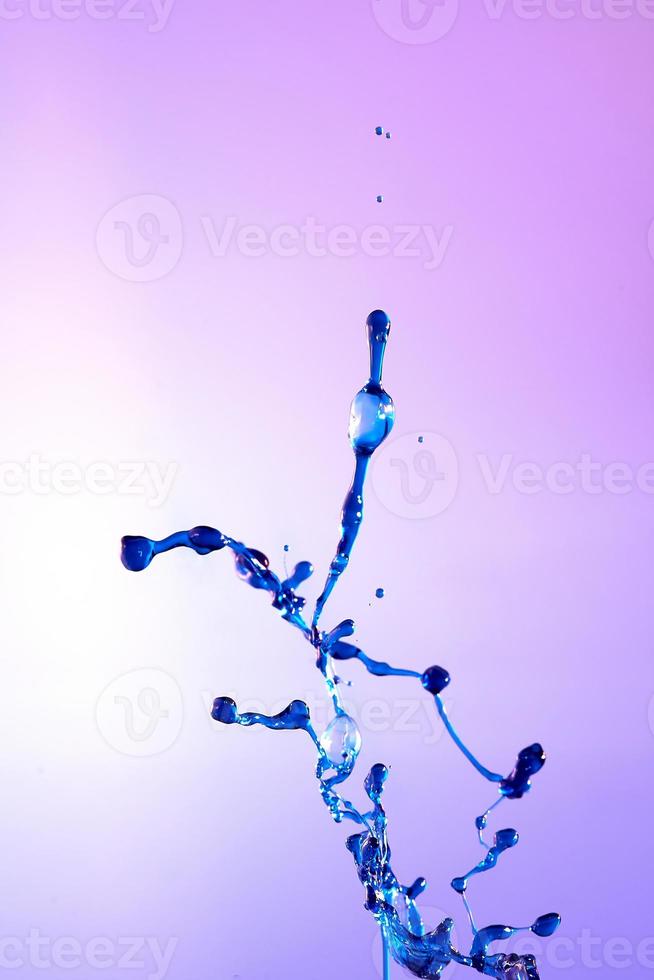 abstrakt lila bakgrund av blå vatten stänk, kollision av färgad droppar. foto
