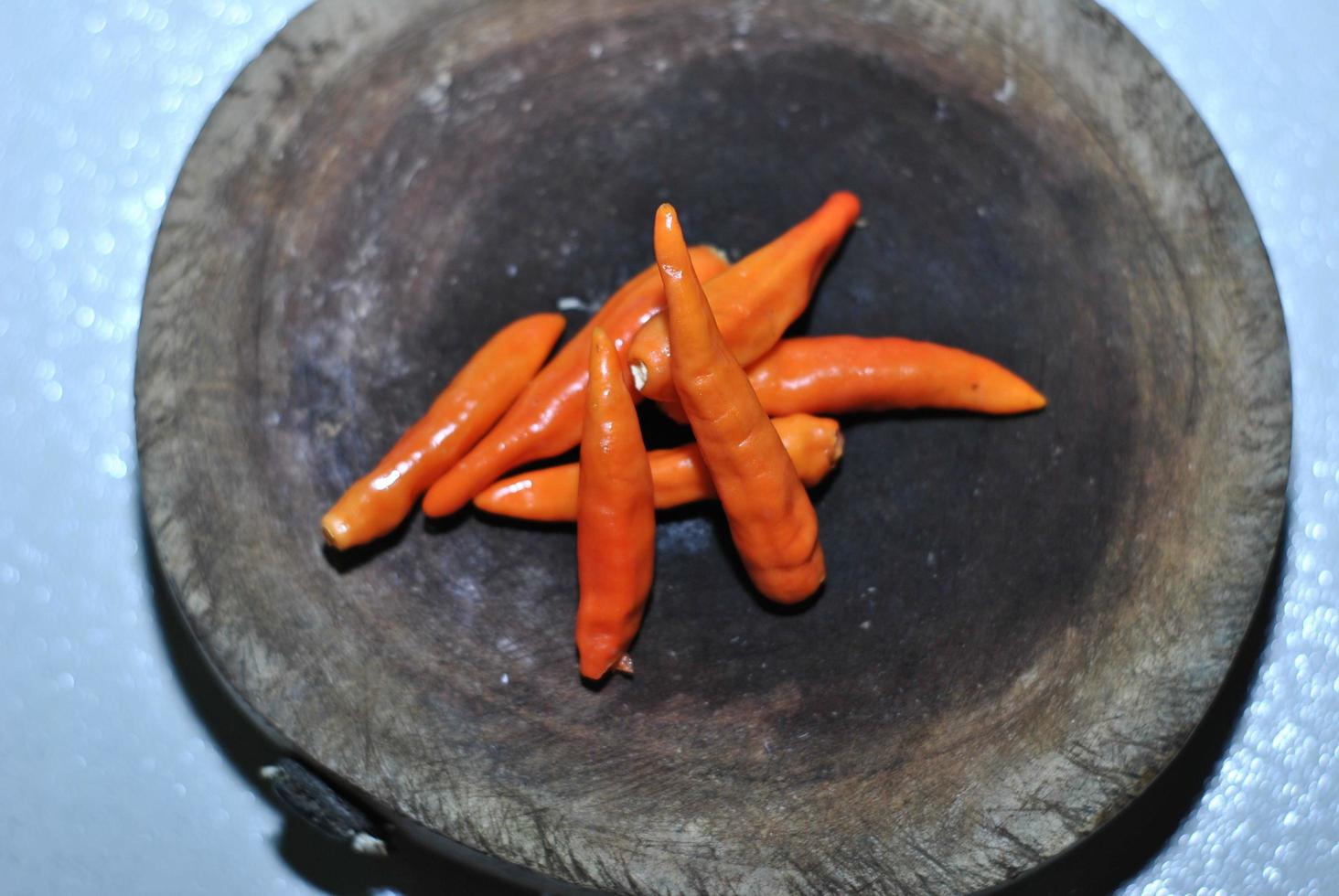 kryddad röd chili med skärande styrelse bakgrund foto