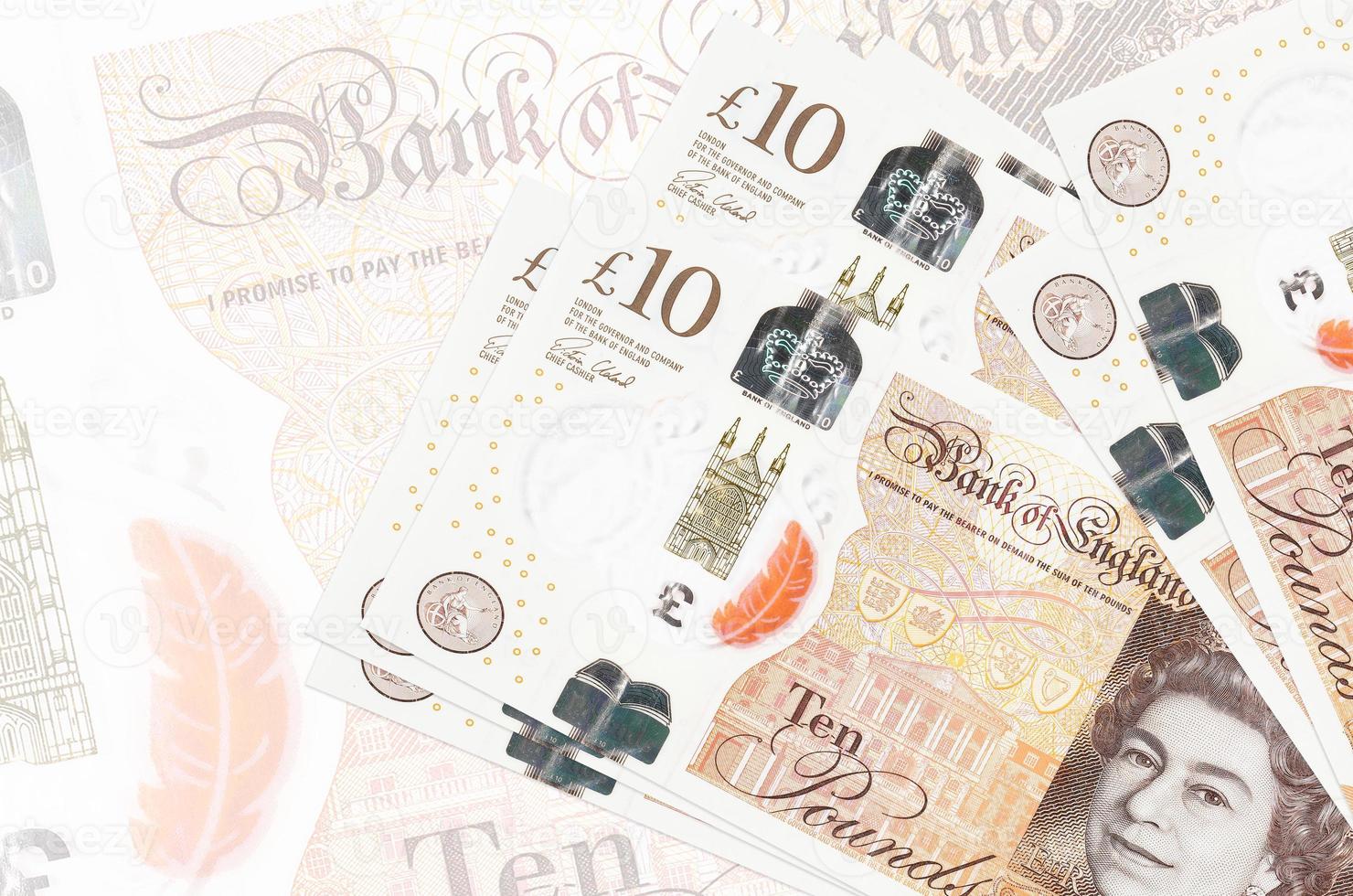 10 brittiskt pounds räkningar lögner i stack på bakgrund av stor halvtransparent sedel. abstrakt presentation av nationell valuta foto