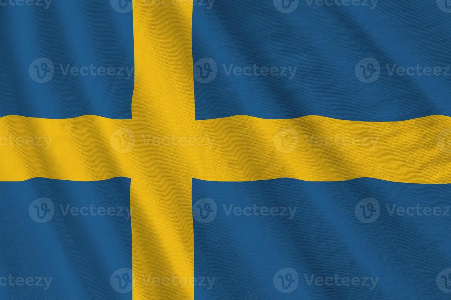 Sverige flagga med stor veck vinka stänga upp under de studio ljus inomhus. de officiell symboler och färger i baner foto