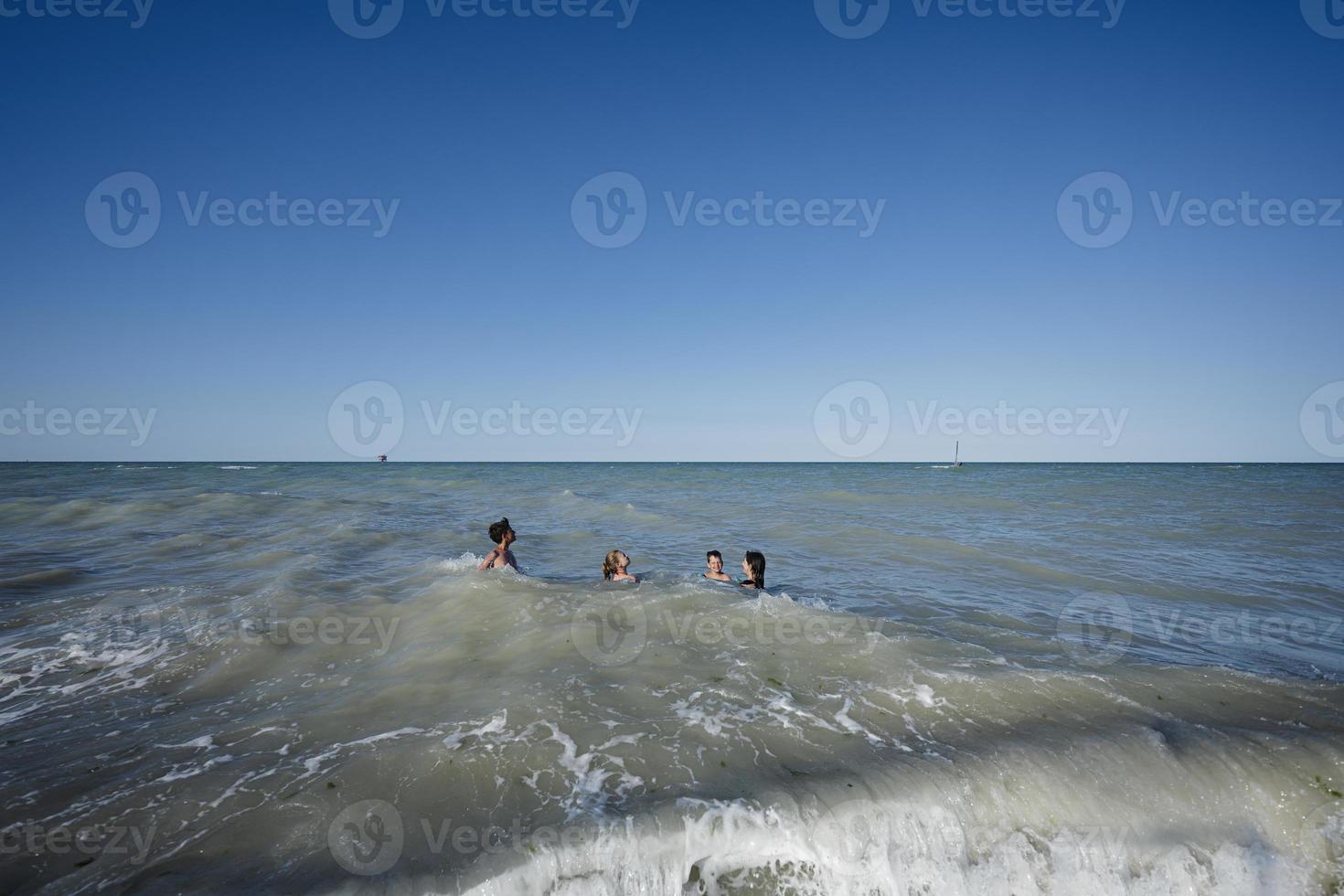 familj med barn simning i adriatisk hav på strand porto sant elpidio, Italien. foto