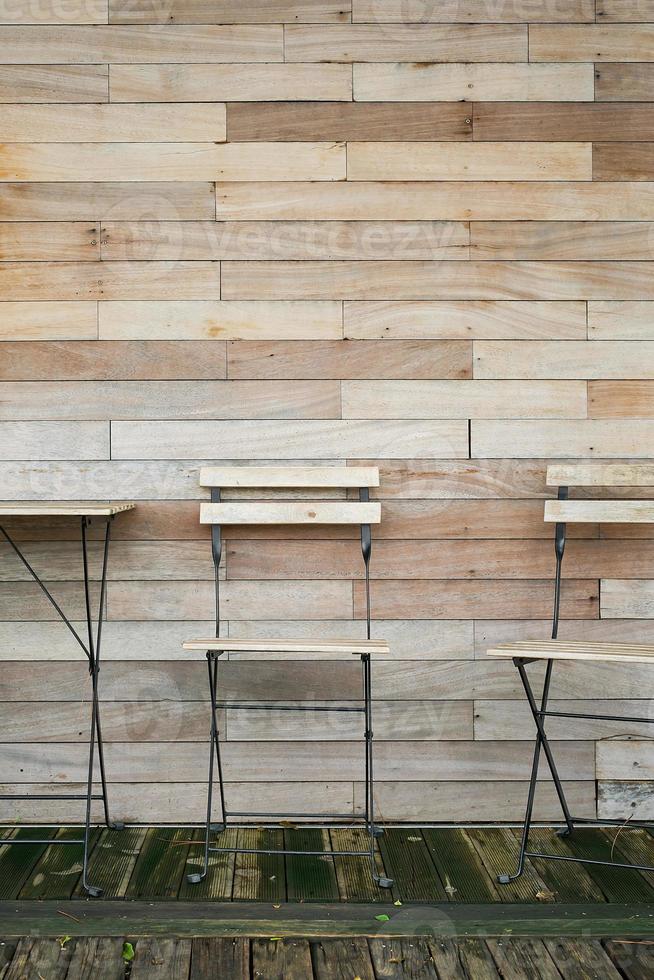 kaffe interiör dekoration från naturlig material, tabell och stolar mot de trä- vägg av de restaurang, aning för de exteriör. vertikal ram foto