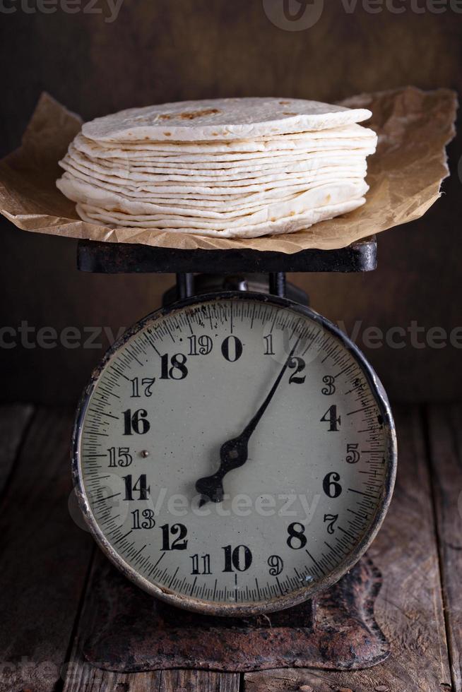 stack av vete tortillas på årgång kök skalor foto