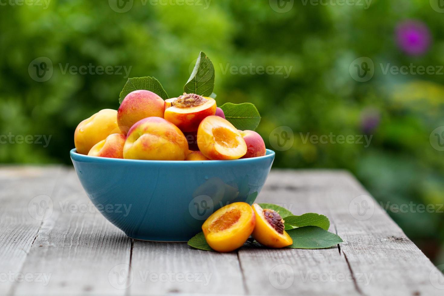 färska persikor i blå skål foto