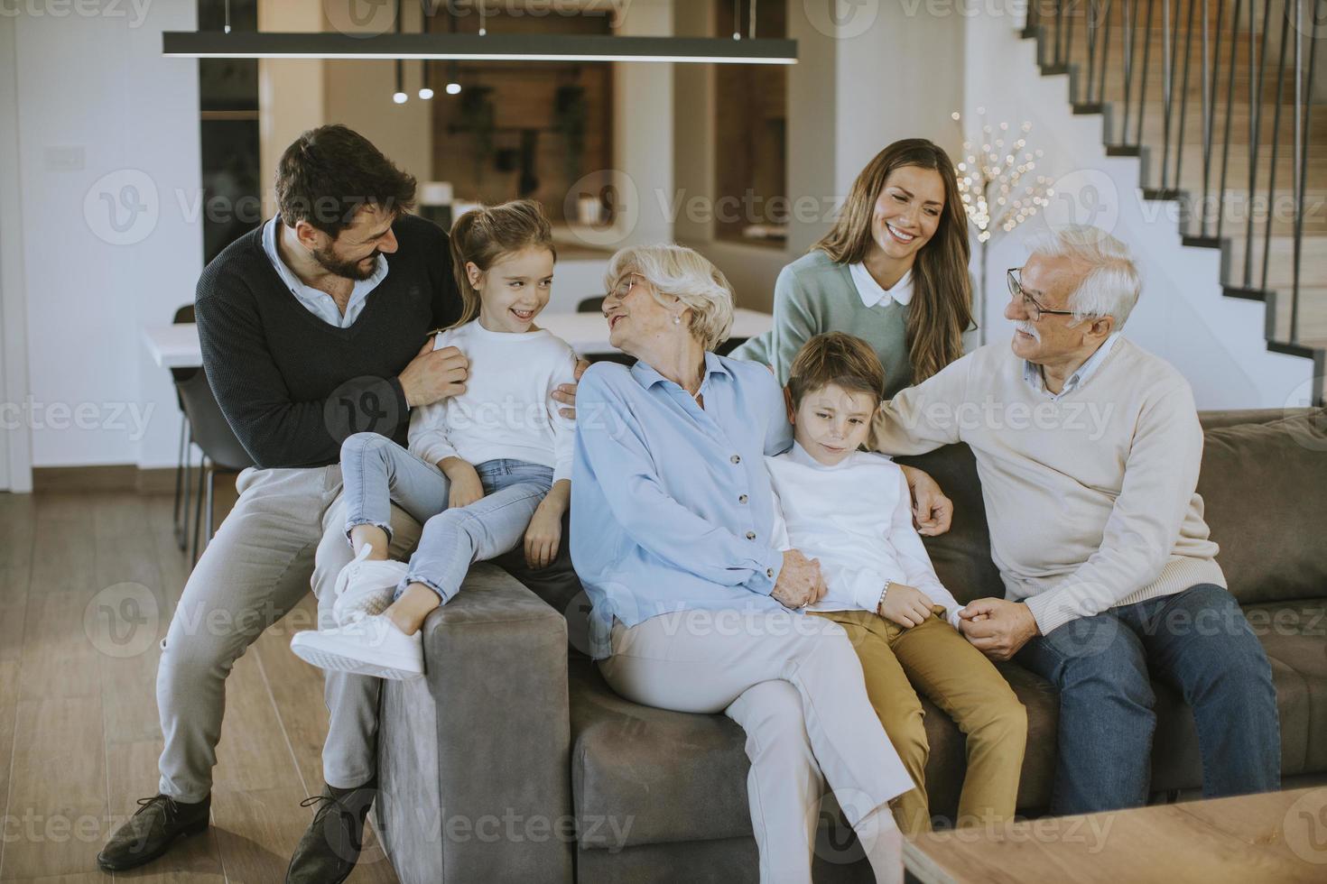 mång generation familj Sammanträde tillsammans på de soffa på Hem och tittar på TV foto