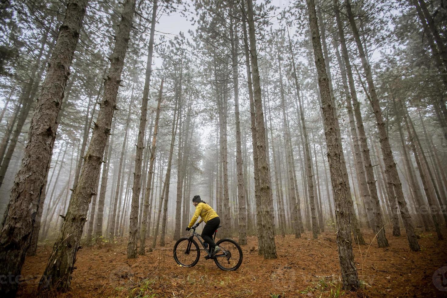ung man cykling genom höst skog foto