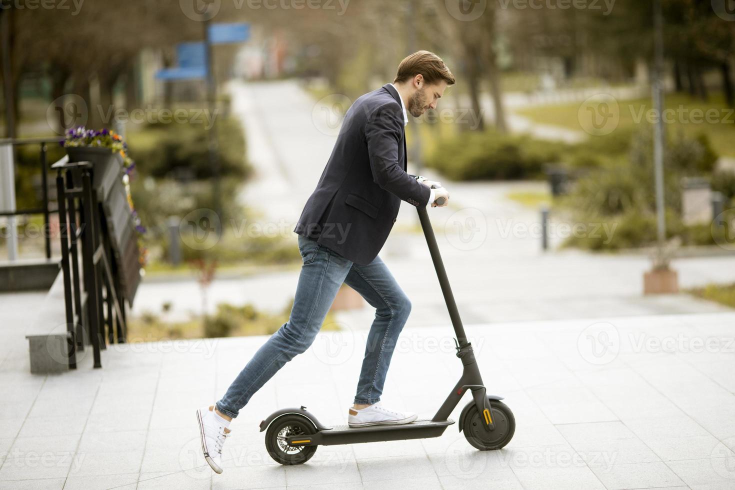 ung affärsman ridning elektrisk skoter foto