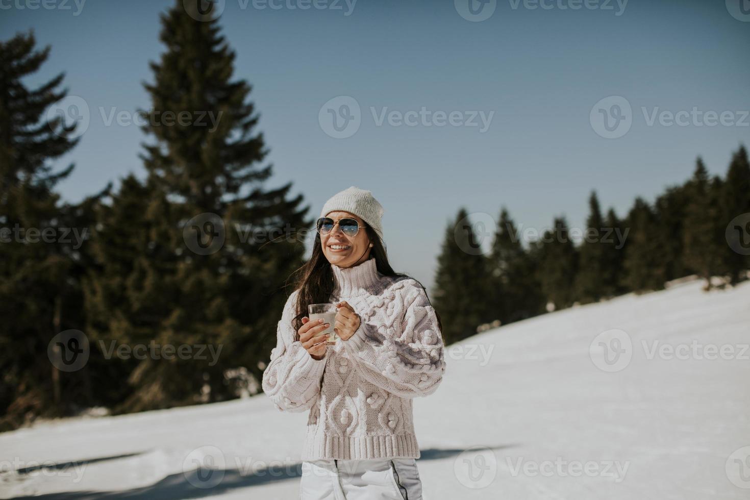 ung kvinna dricka citronsaft på de berg åka skidor Spår foto