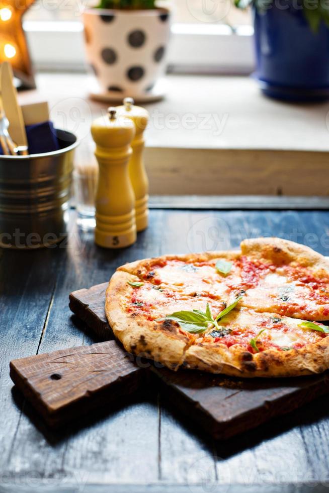 pizza margherita nyligen bakad på en tabell i Kafé foto