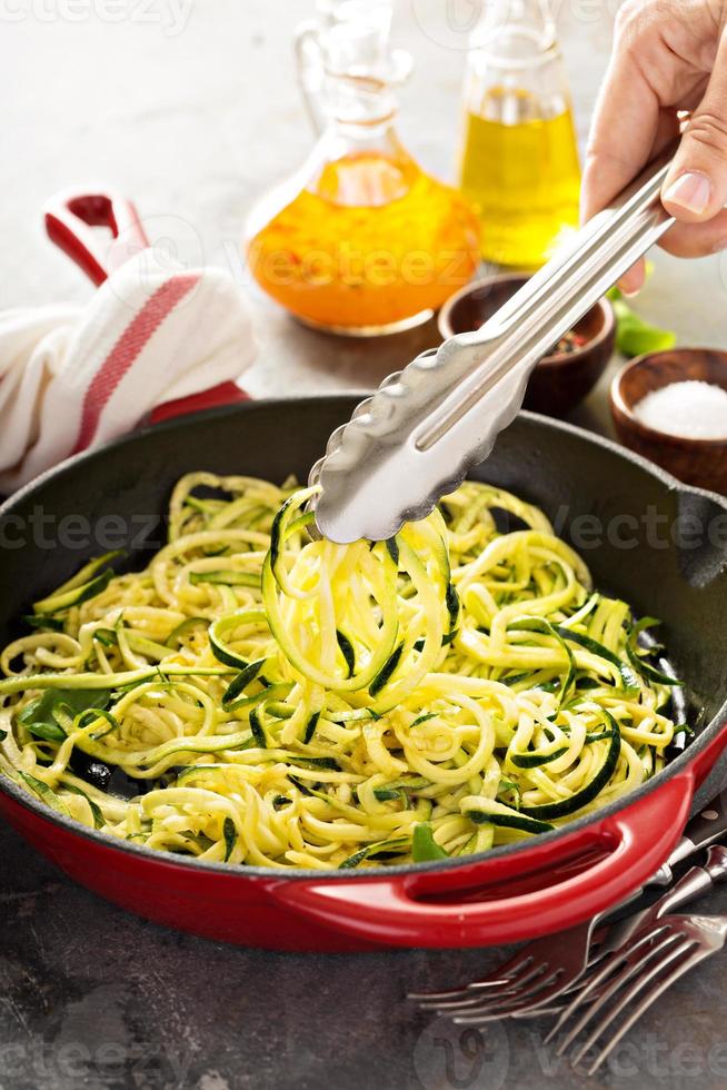 spiraliserad zucchini spaghetti i en kasta järn panorera foto