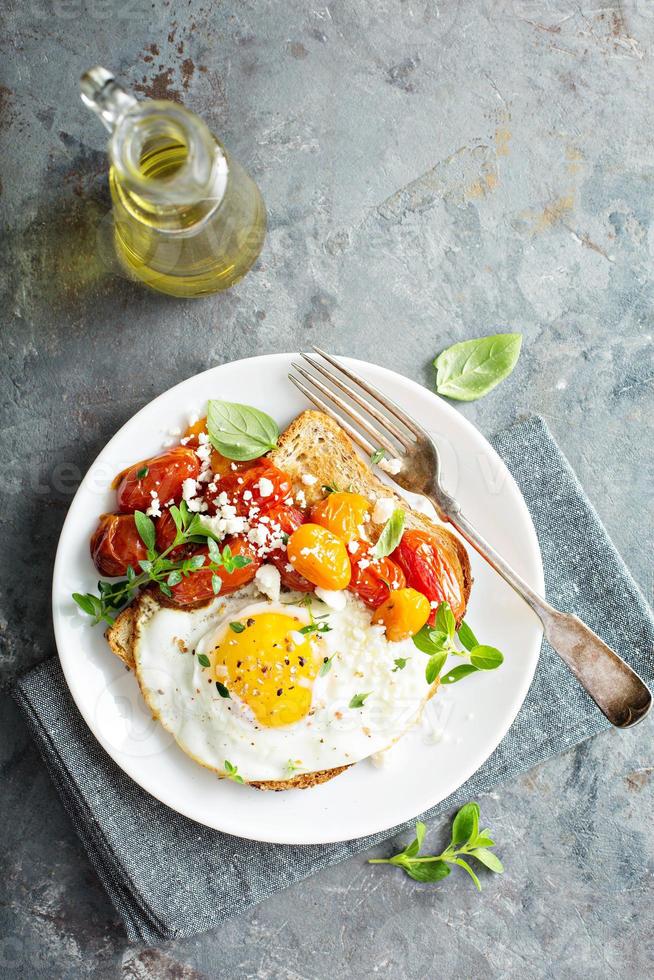 multigrain rostat bröd med friterad ägg och rostad tomater foto