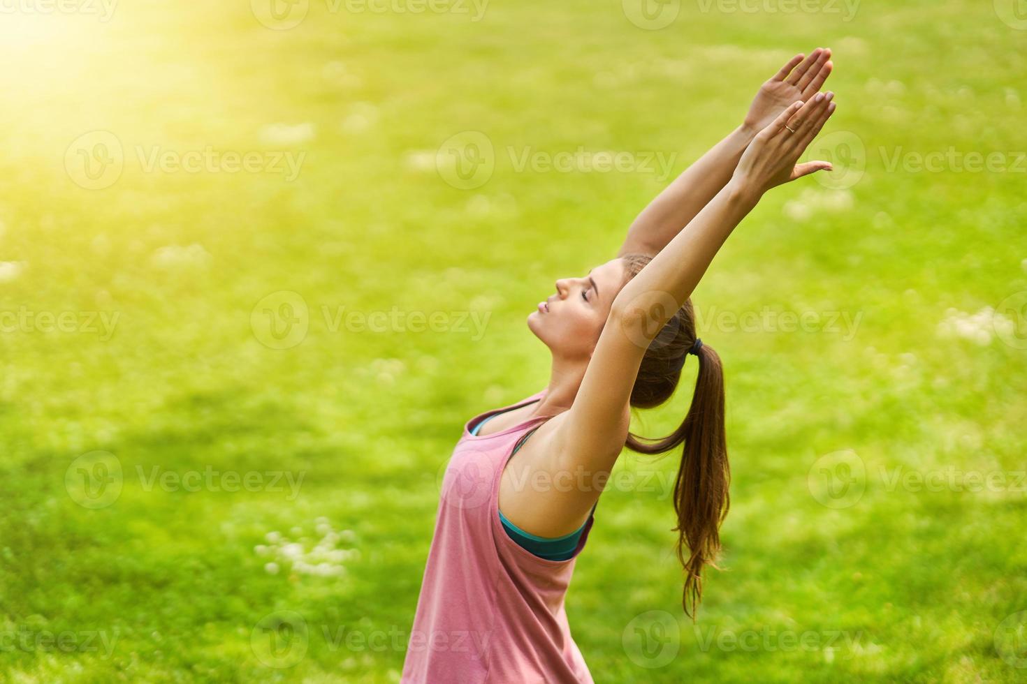 ung kvinna håller på med yoga i parkera foto