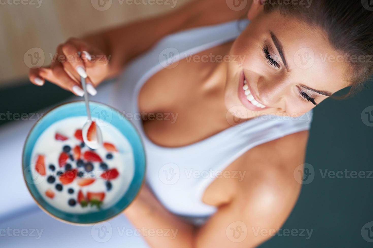 porträtt av skön latinamerikan kvinna äter yoghurt främja friska livsstil foto
