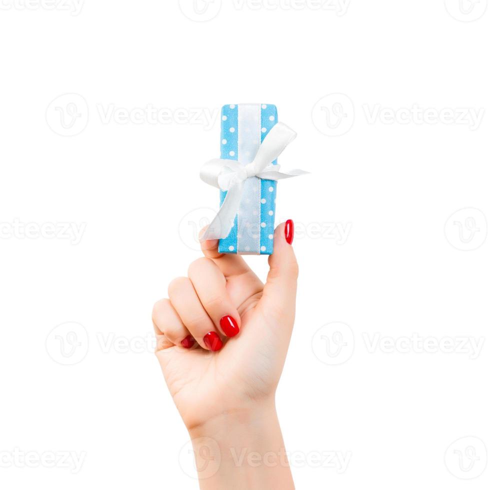 kvinna händer ge insvept jul eller Övrig Semester handgjort närvarande i blå papper med vit band. isolerat på vit bakgrund, topp se. tacksägelse gåva låda begrepp foto