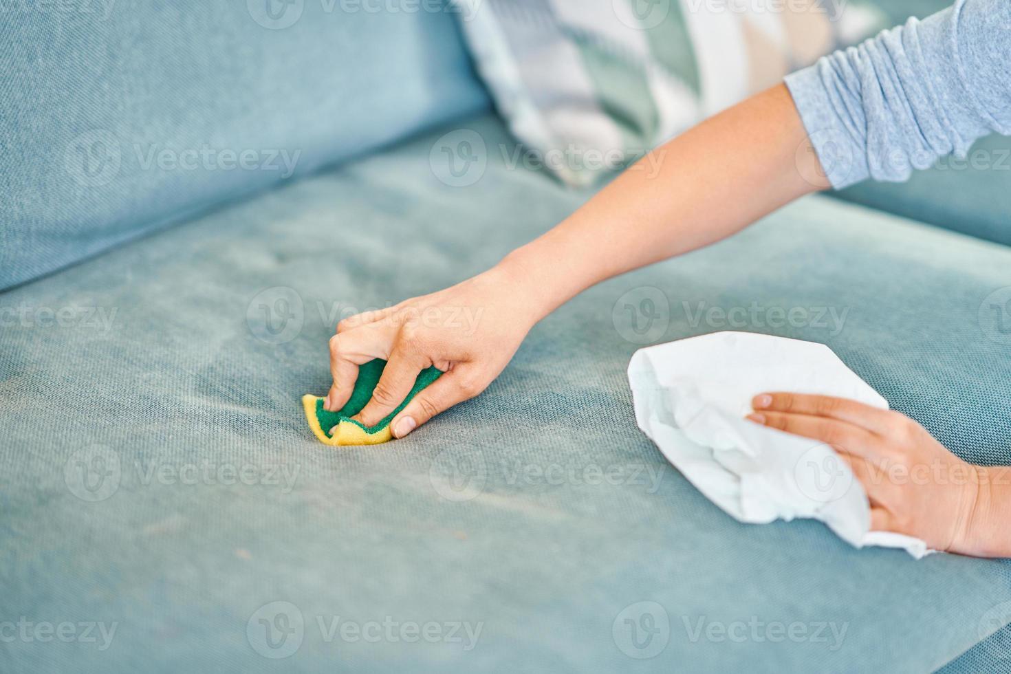 bild av kvinna rengöring soffa med svamp foto
