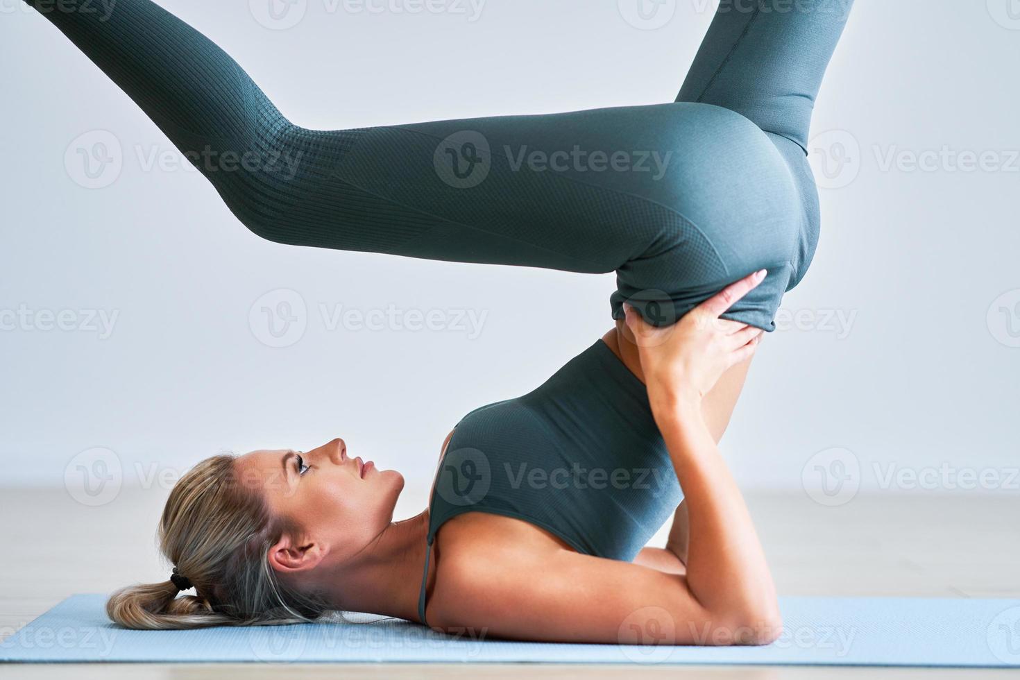 vuxen kvinna praktiserande yoga på Hem foto