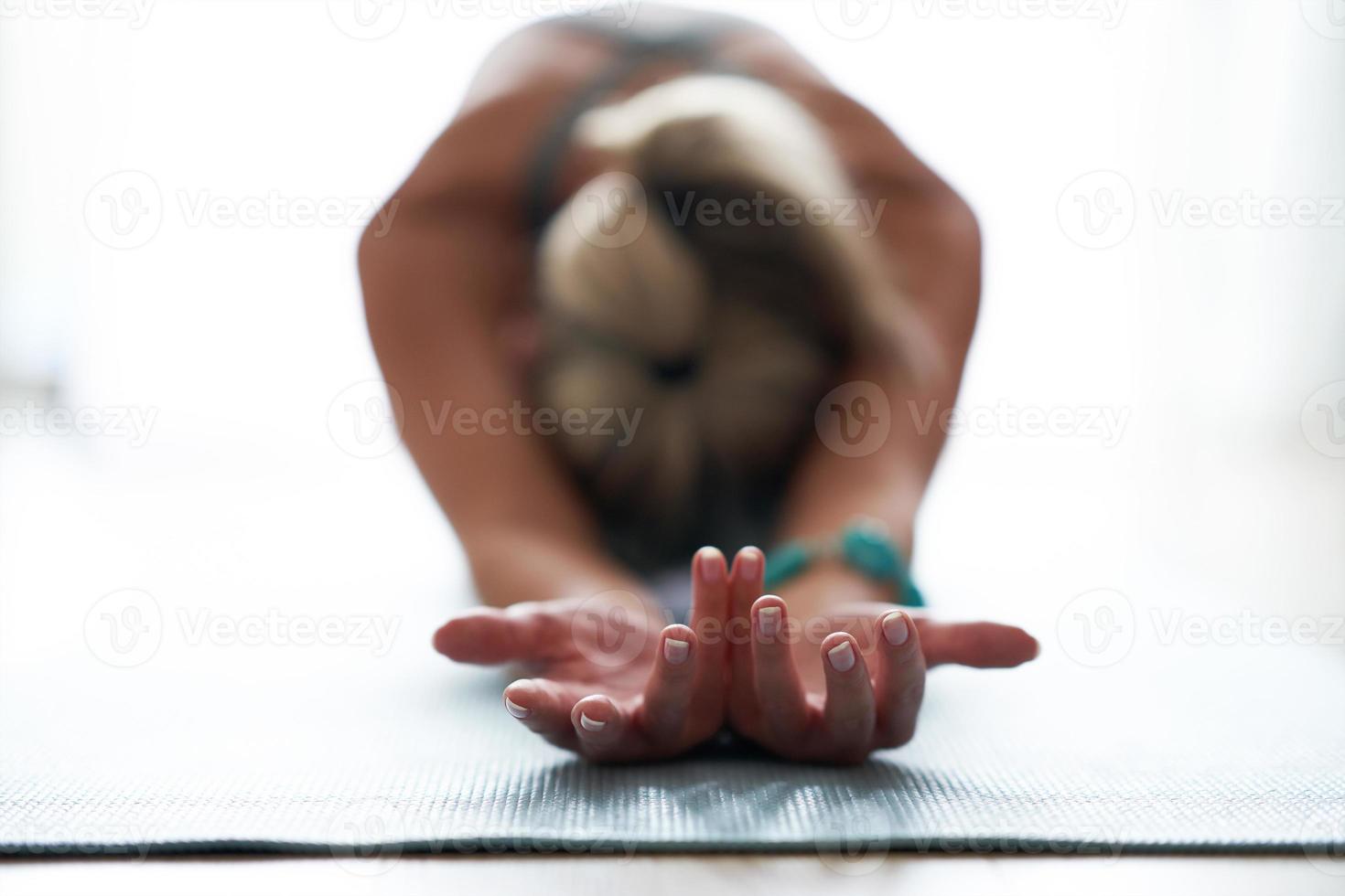 vuxen kvinna praktiserande yoga på Hem foto