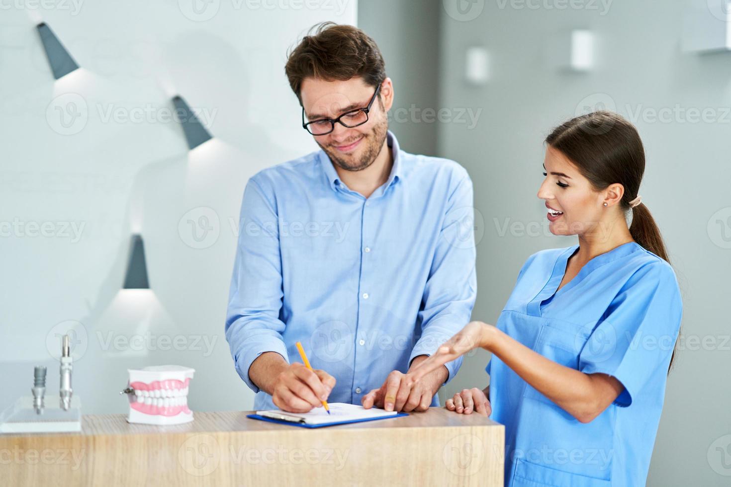 patient signering dokument i dental klinik foto
