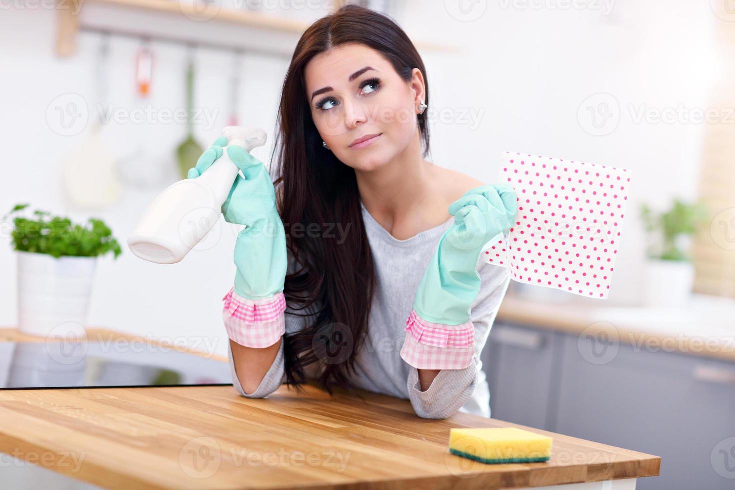 skön ung kvinna rengöring de kök foto