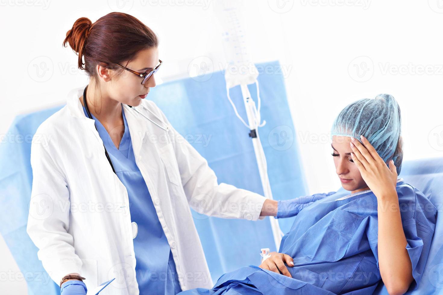 kvinna läkare tar vård av patient i sjukhus foto