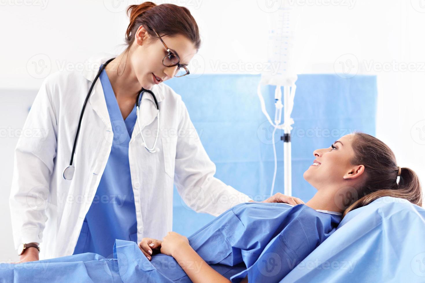 kvinna läkare tar vård av patient i sjukhus foto