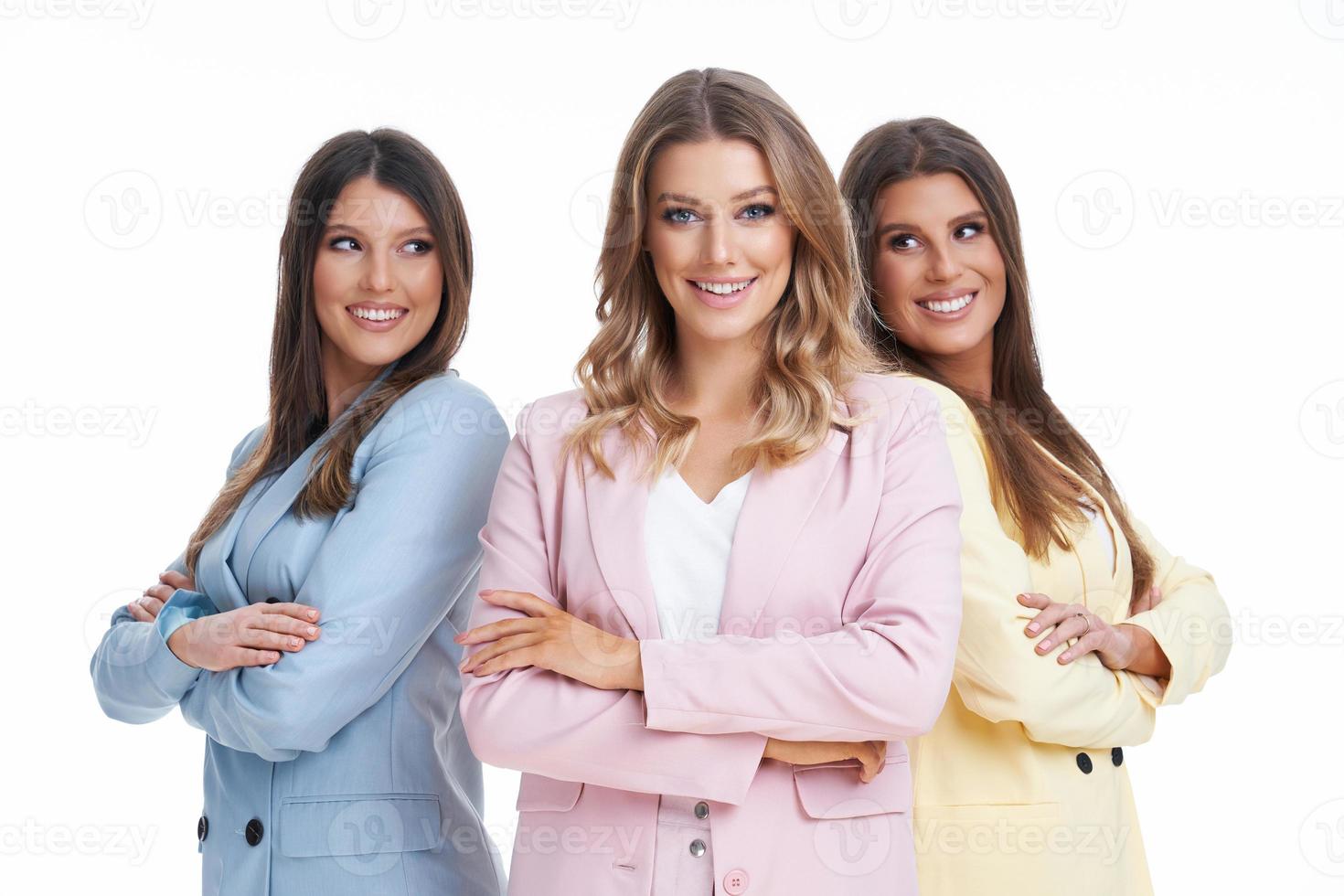 tre kvinnor i pastell kostymer Framställ över vit bakgrund foto