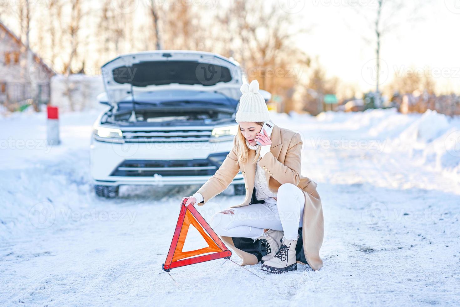 ung kvinna har problem med bil i vinter- foto