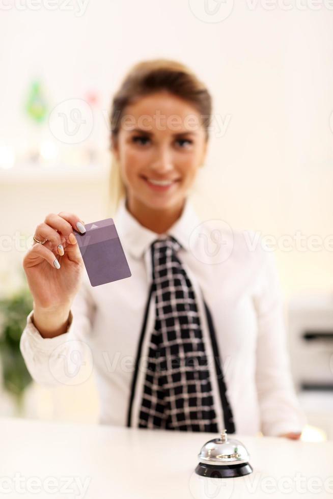 Lycklig receptionist arbetssätt i hotell foto