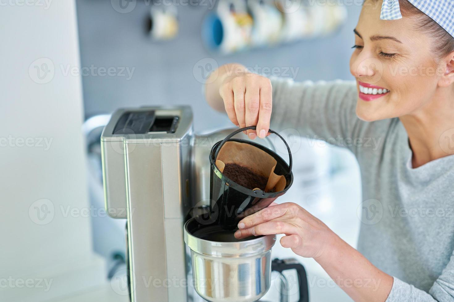 ung kvinna med kaffe grunder använda sig av den för peeling foto