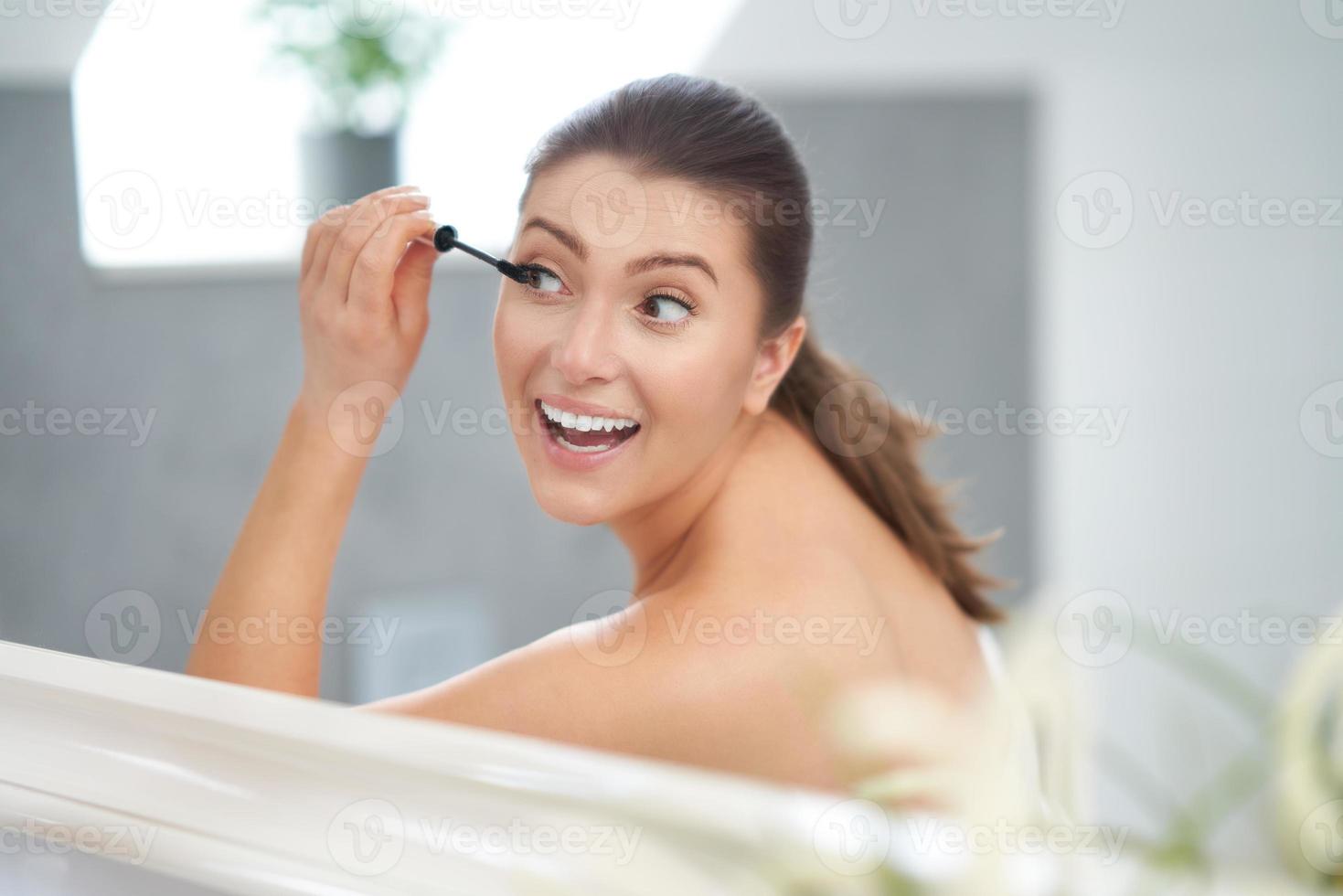 ung trevlig brunett kvinna i de badrum foto
