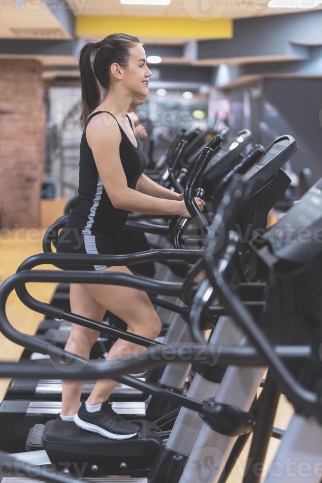 kvinna håller på med en träna med hantlar på de kondition Gym. foto