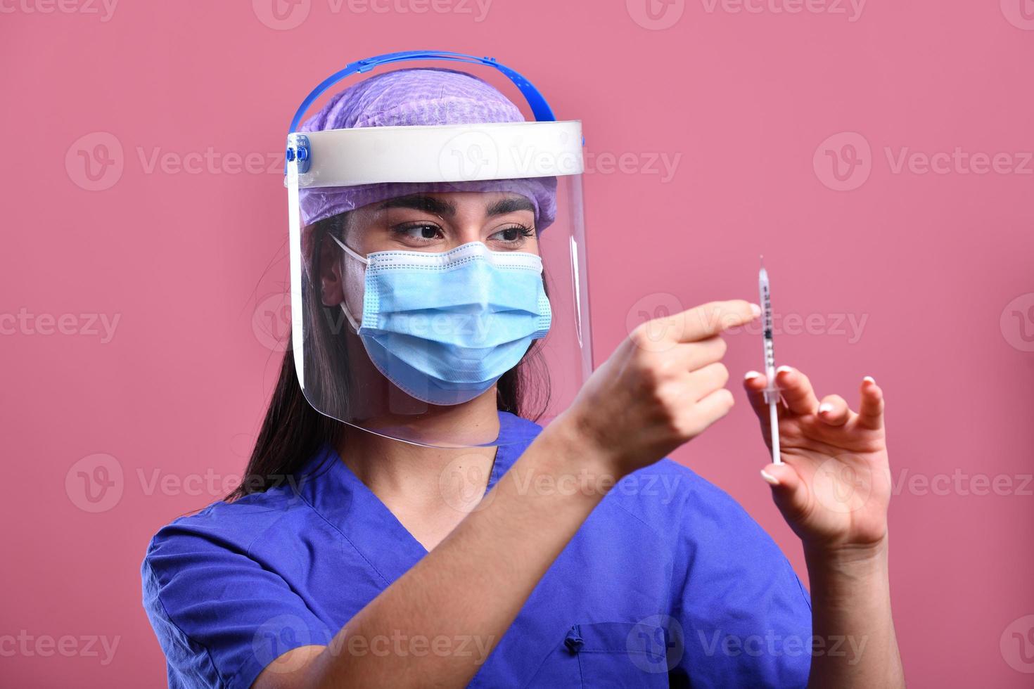 kvinna läkare bär ansikte skydda och ppe kostym för coronavirus utbrott innehav vaccin och covid testa. begrepp av covid-19 foto