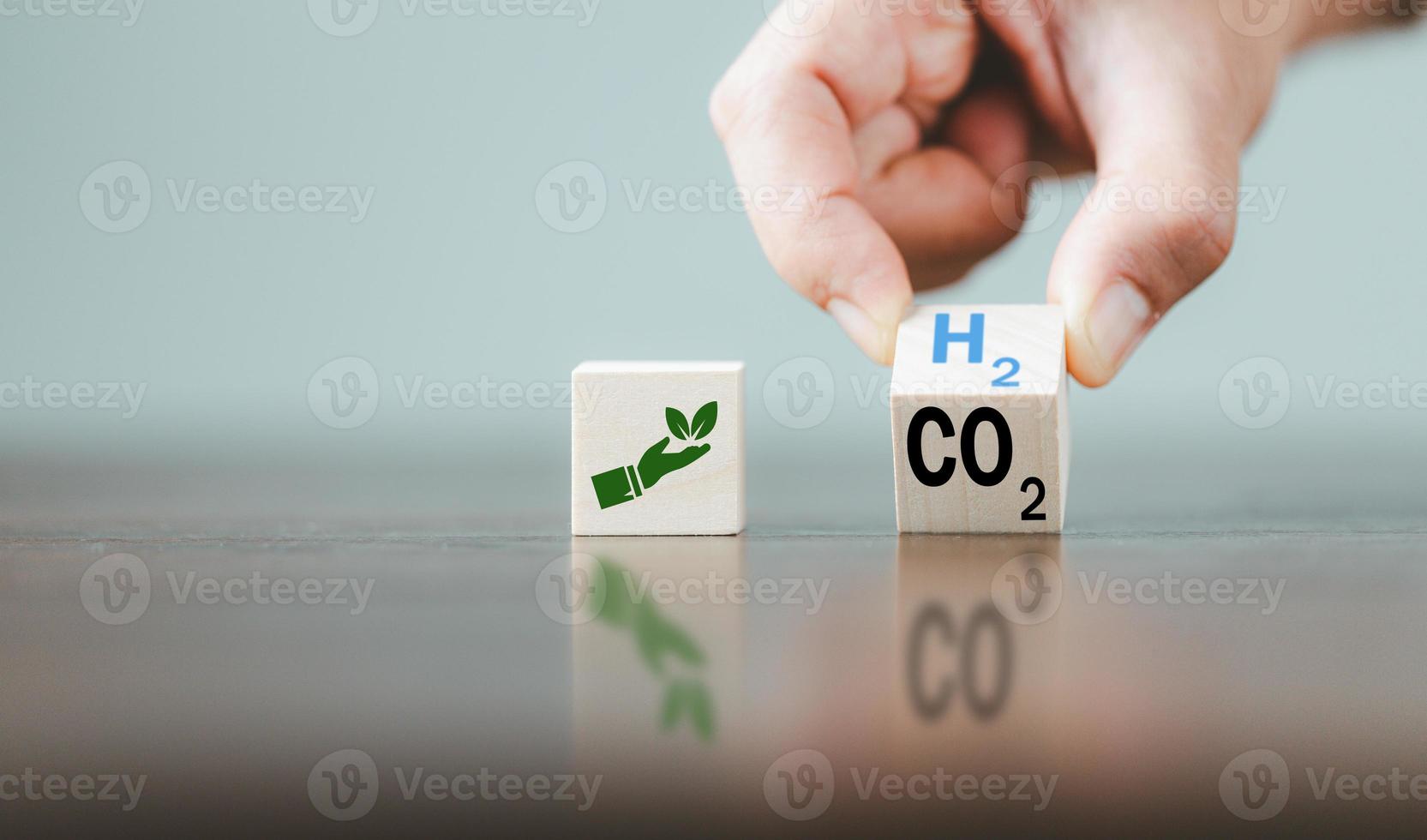fri kol, alternativ energi och global klimat förändra begrepp. hand vända trä- kub block med co2 kol dioxid, förändra till h2 väte text på tabell bakgrund. hållbar bil energi. foto