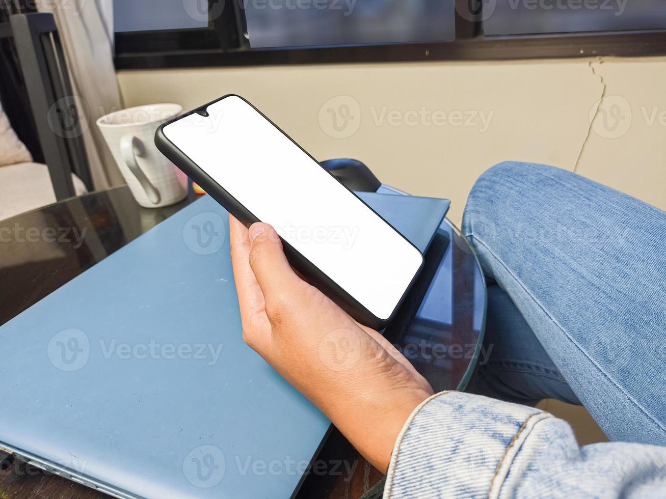 närbild av en kvinna hand innehav en smartphone vit skärm är tom .mockup. foto