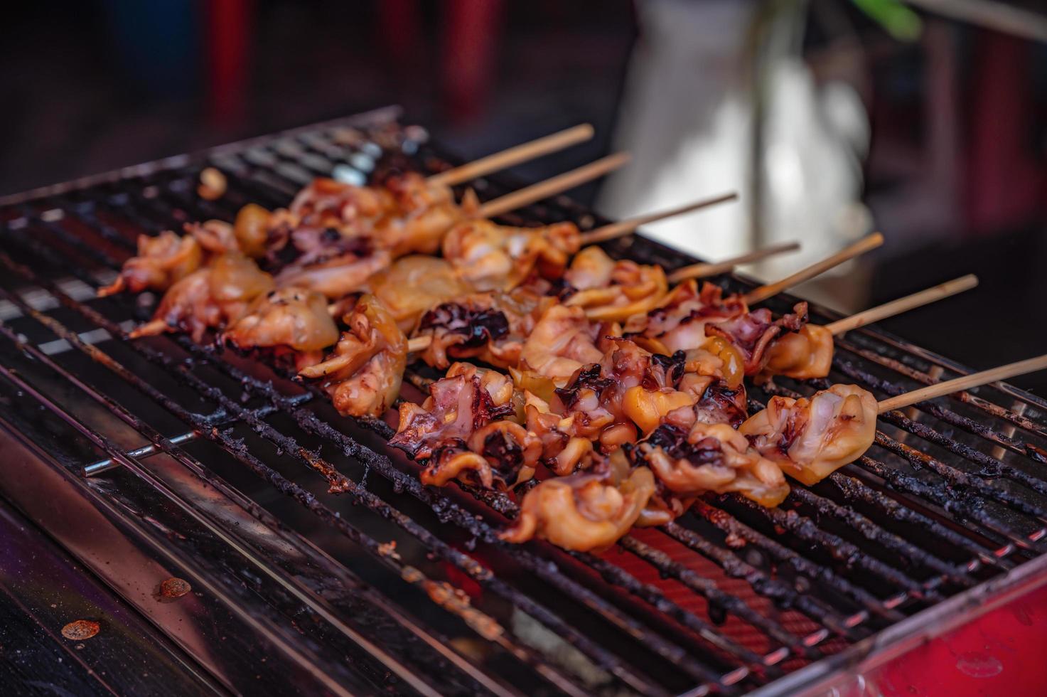 stänga upp rå bläckfisk kött grillspett på banan blad i de färsk marknadsföra av thailand med kryddad skaldjur sauce.thailand gata mat foto