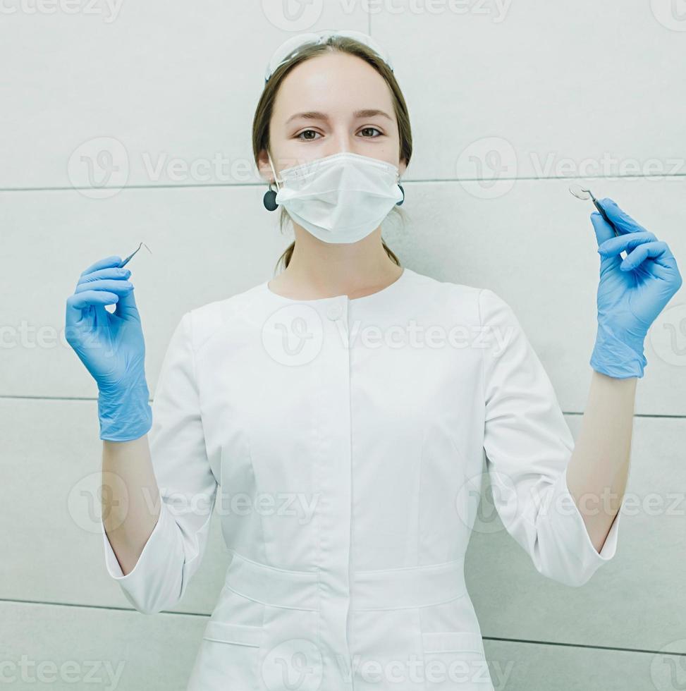 en kvinna tandläkare i en vit täcka foto