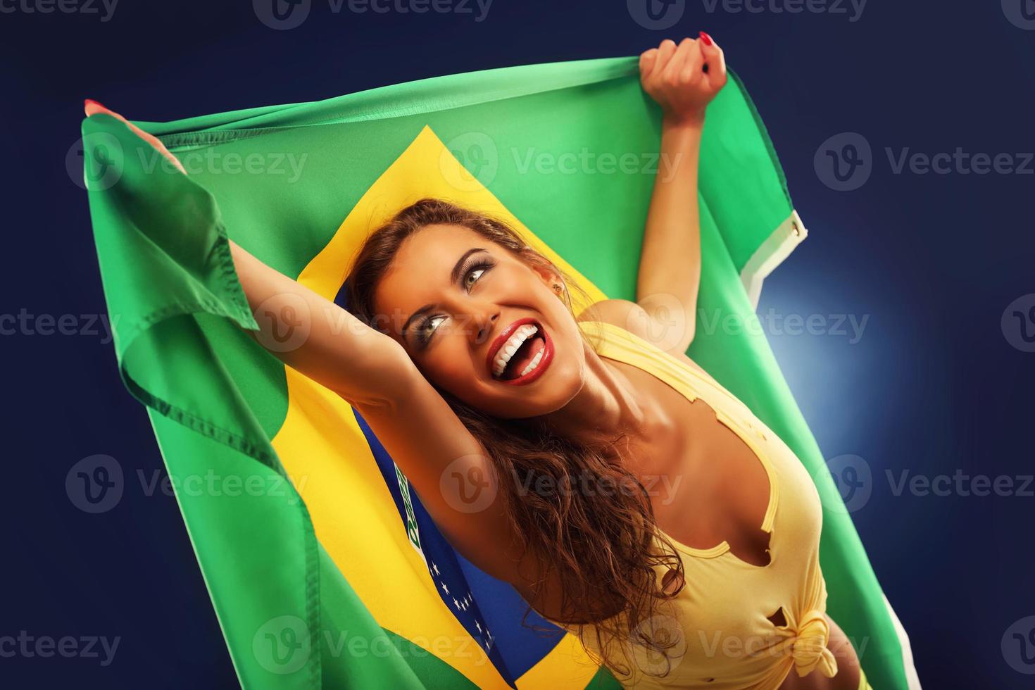 Lycklig brasiliansk fläkt glädjande med flagga foto